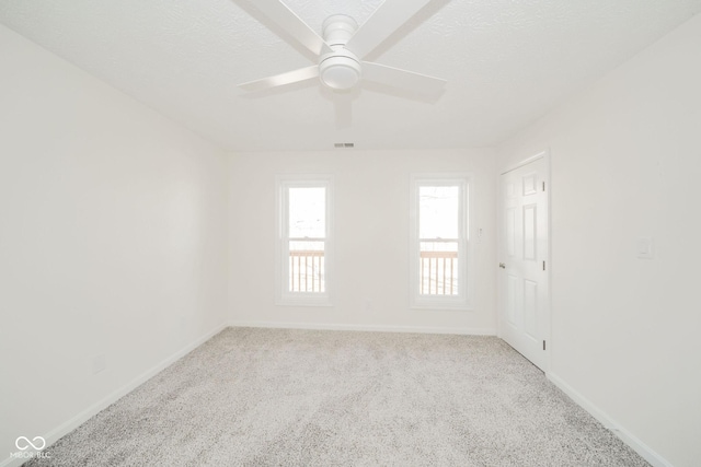 unfurnished room featuring light carpet, baseboards, visible vents, and a textured ceiling