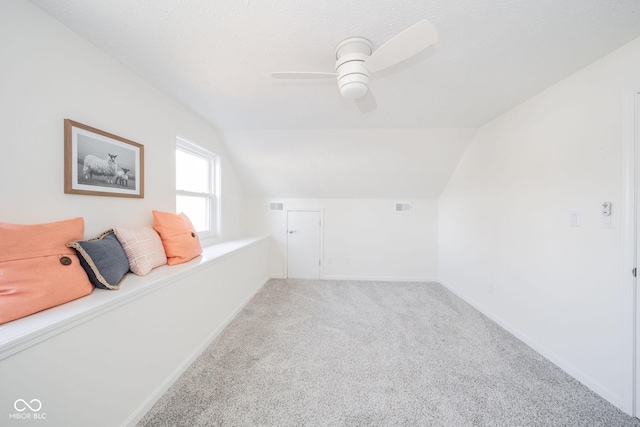 bonus room with lofted ceiling, carpet flooring, a ceiling fan, and baseboards