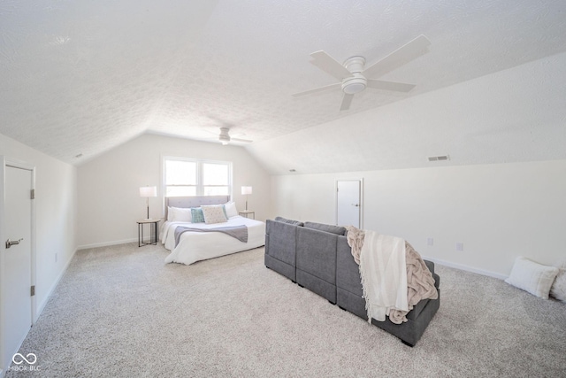 bedroom with light carpet, visible vents, a ceiling fan, vaulted ceiling, and a textured ceiling