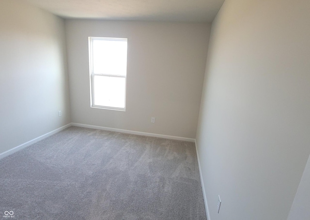 carpeted empty room with baseboards