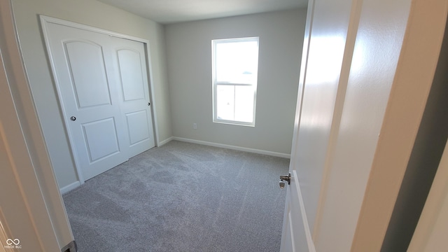 unfurnished bedroom featuring carpet and baseboards