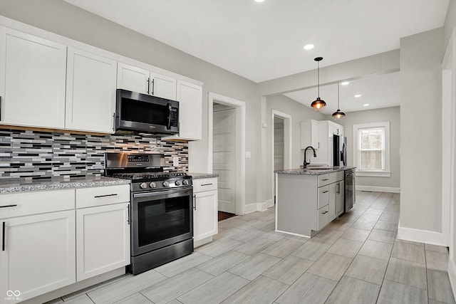 5053 E Michigan St, Indianapolis, IN 46201 - kitchen with appliances with stainless steel finishes, a sink, decorative backsplash, baseboards, and recessed lighting