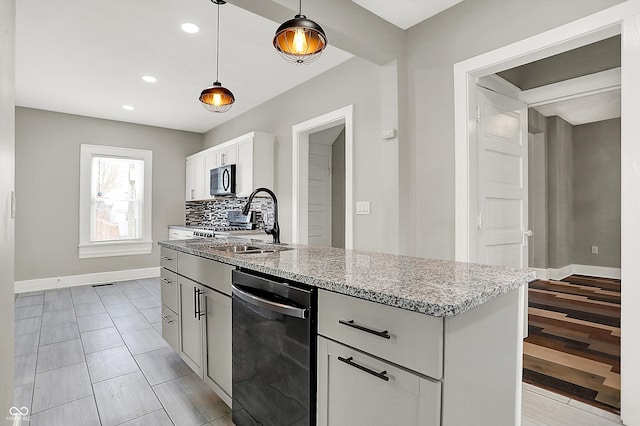 5053 E Michigan St, Indianapolis, IN 46201 - kitchen featuring dishwasher, a sink, light stone countertops, stainless steel microwave, and baseboards