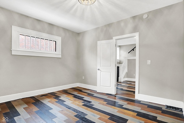 5053 E Michigan St, Indianapolis, IN 46201 - spare room featuring baseboards, wood finished floors, and stairway