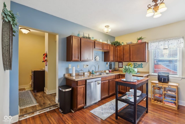 kitchen featuring dark wood finished floors, light countertops, a sink, dishwasher, and baseboards