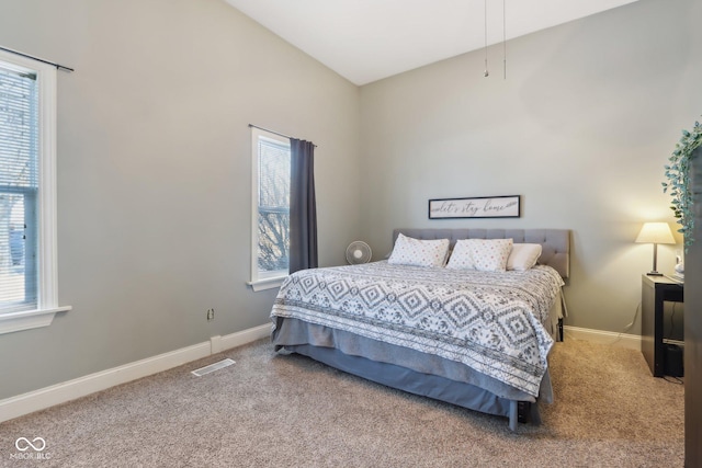 carpeted bedroom featuring visible vents, baseboards, and multiple windows