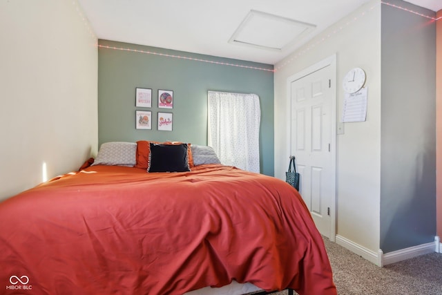 carpeted bedroom with attic access and baseboards