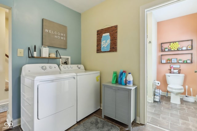 laundry room with laundry area, tile patterned floors, washing machine and dryer, and baseboards