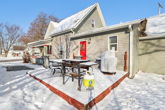 view of snow covered back of property