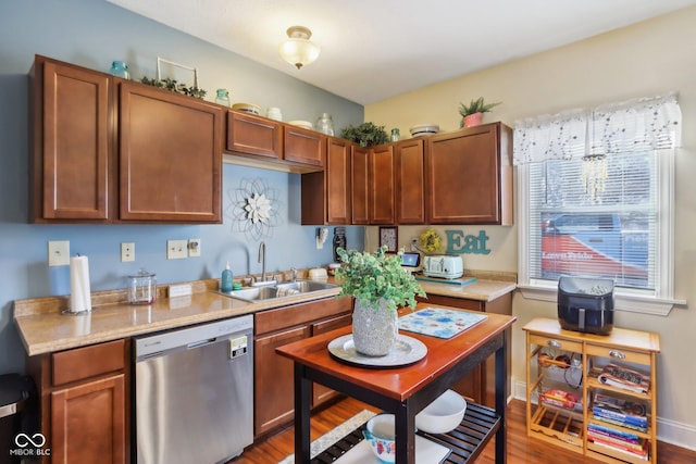 kitchen featuring a sink, brown cabinetry, light countertops, and dishwasher