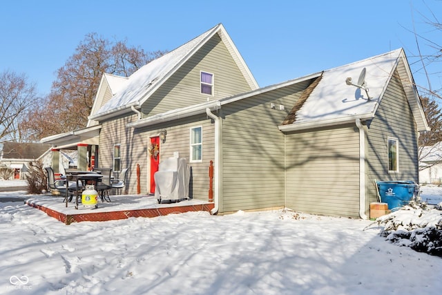 view of snow covered rear of property