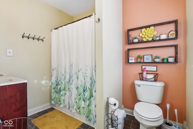 bathroom with baseboards, vanity, toilet, and tile patterned floors