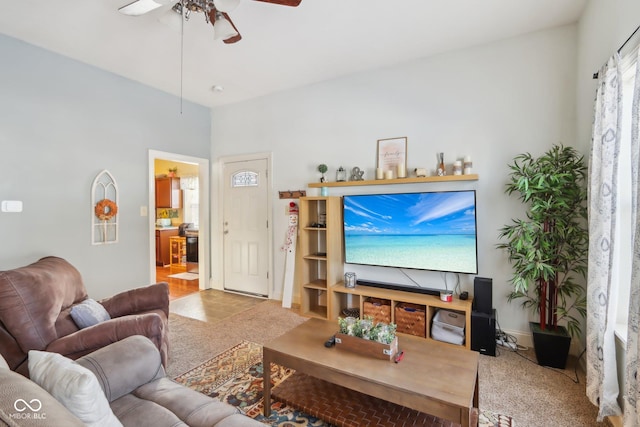 living room featuring a ceiling fan, light carpet, and baseboards