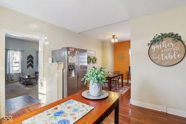 dining area with baseboards and dark wood finished floors