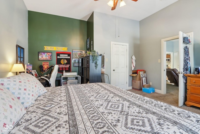 bedroom with a ceiling fan, a high ceiling, baseboards, and carpet flooring