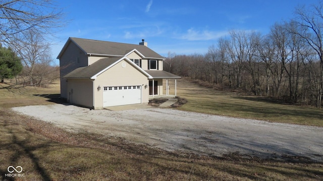 view of front of house with a porch, a front yard, driveway, and a chimney