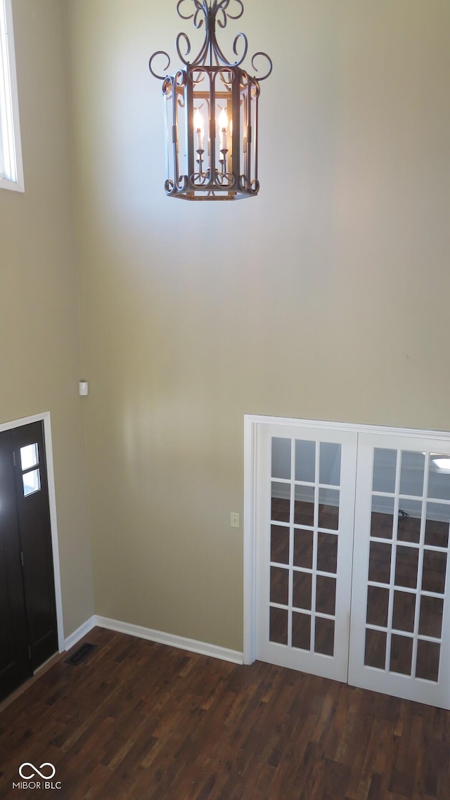 interior space with a chandelier, baseboards, and wood finished floors