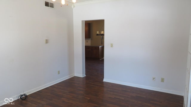 unfurnished room featuring dark wood-style floors, baseboards, and visible vents