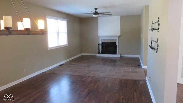 unfurnished living room featuring a fireplace, wood finished floors, and baseboards