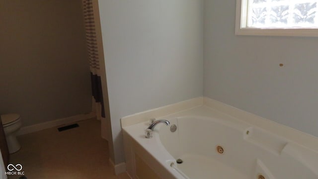 bathroom featuring visible vents, toilet, and a tub with jets