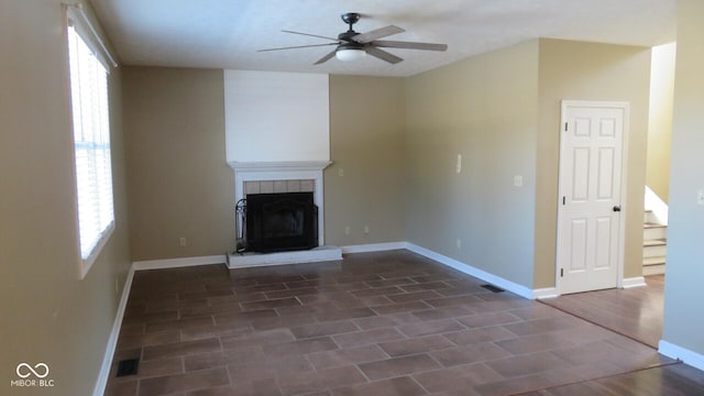 unfurnished living room featuring a healthy amount of sunlight, a fireplace, and baseboards