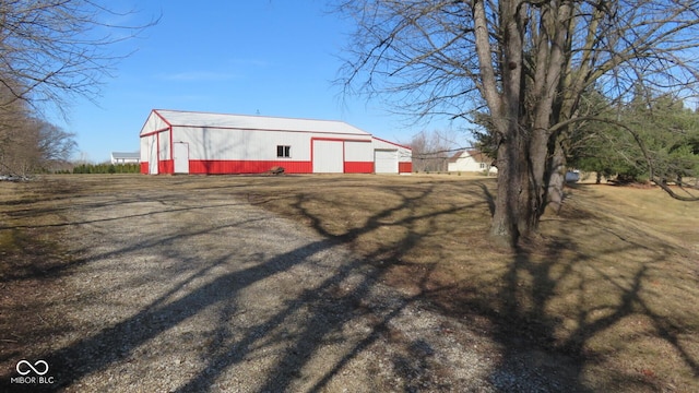 exterior space featuring a garage, a pole building, and an outdoor structure