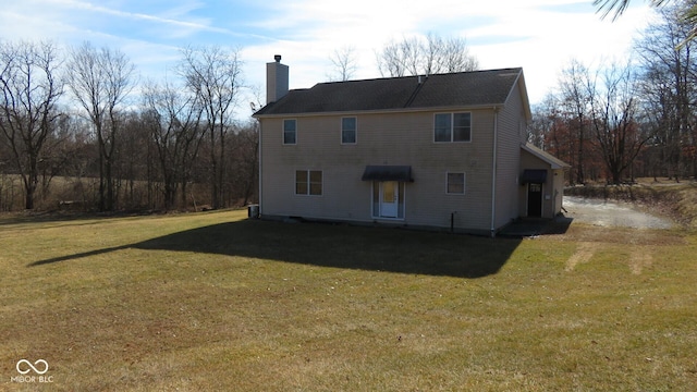 back of property featuring a lawn and a chimney