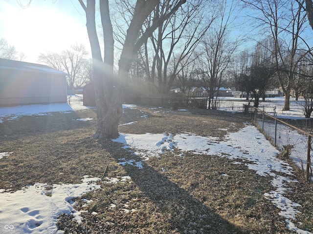 snowy yard featuring fence