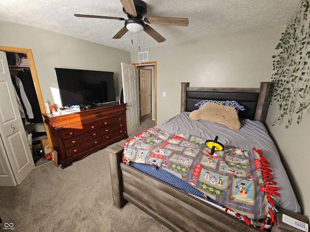 carpeted bedroom featuring a closet, visible vents, ceiling fan, and a textured ceiling