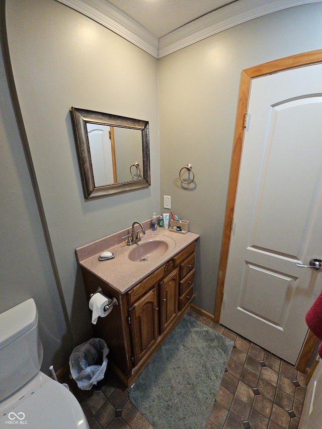 bathroom with toilet, ornamental molding, and vanity