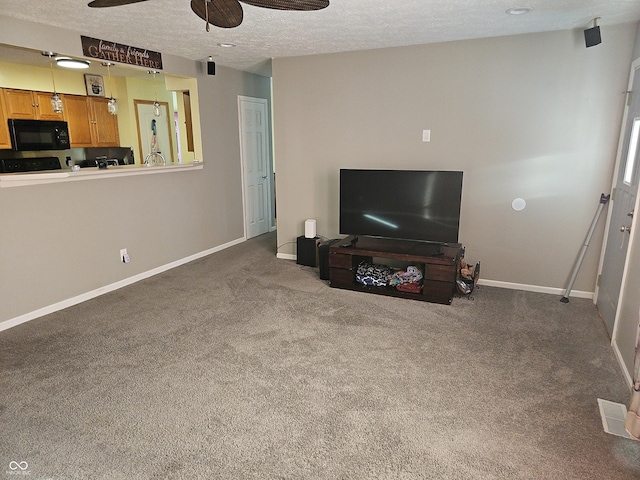 carpeted living area featuring ceiling fan, visible vents, baseboards, and a textured ceiling