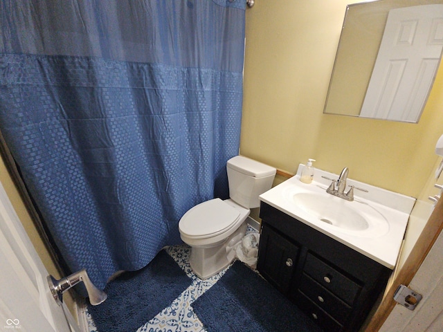 bathroom with curtained shower, vanity, and toilet