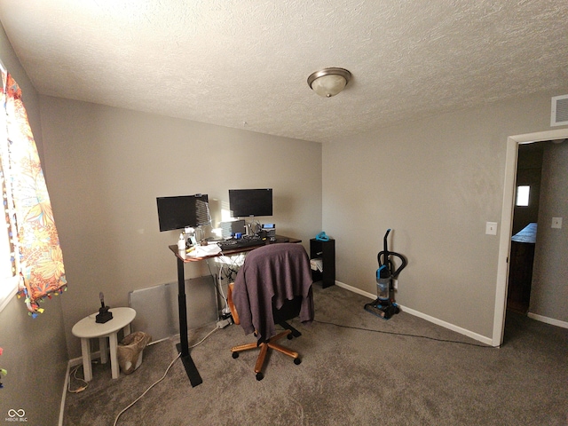 office area with carpet, a textured ceiling, visible vents, and baseboards