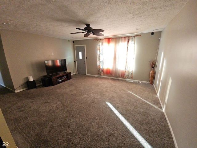 unfurnished living room with carpet flooring, ceiling fan, a textured ceiling, and baseboards