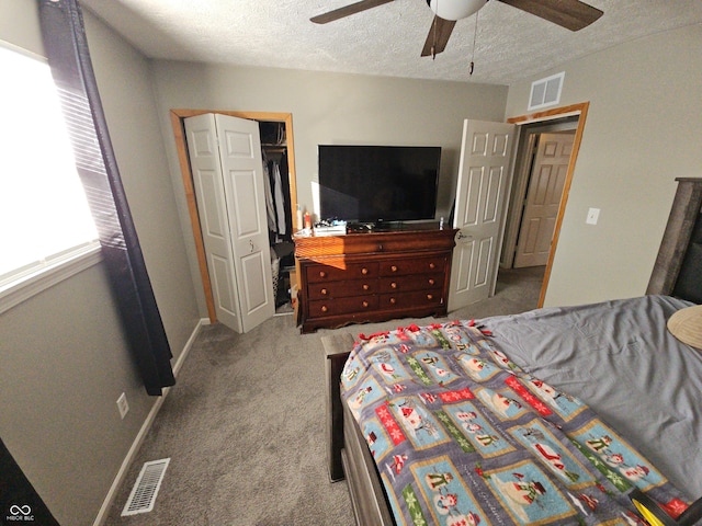 carpeted bedroom featuring visible vents, ceiling fan, a textured ceiling, and baseboards