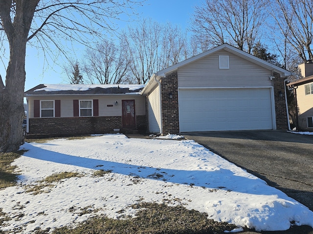 ranch-style home featuring a garage, driveway, and brick siding