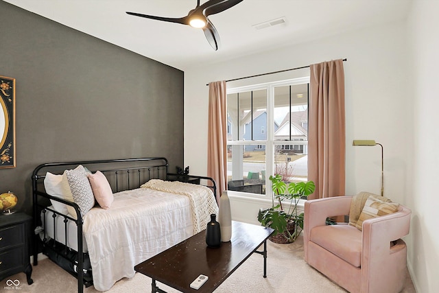 bedroom with light carpet, ceiling fan, and visible vents