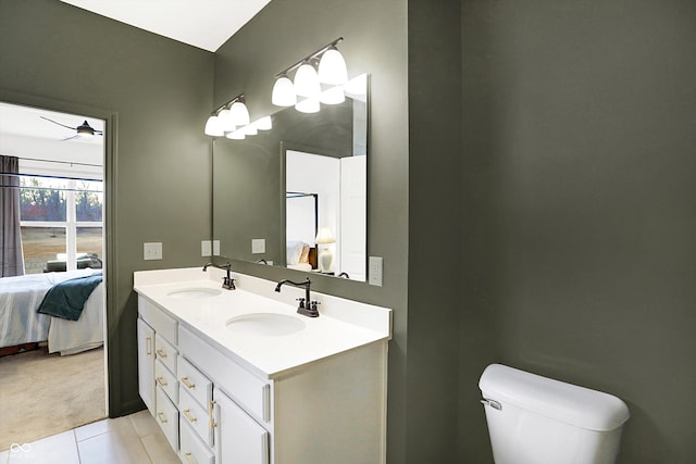 ensuite bathroom featuring a sink, double vanity, ceiling fan, and ensuite bath