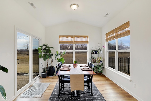 sunroom / solarium with vaulted ceiling, a wealth of natural light, and visible vents