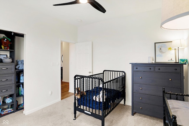 bedroom with light carpet, ceiling fan, and baseboards