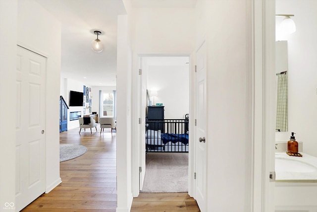 corridor with a sink and light wood-style floors