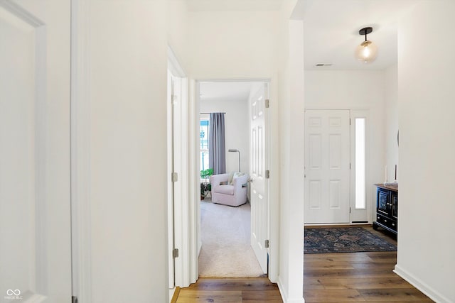 foyer with hardwood / wood-style flooring, baseboards, and visible vents