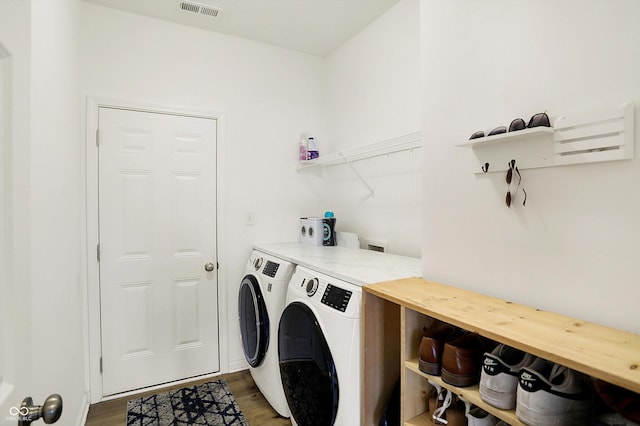 clothes washing area featuring light wood-type flooring, laundry area, visible vents, and separate washer and dryer