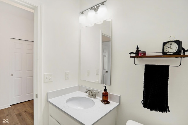 half bathroom featuring vanity and wood finished floors