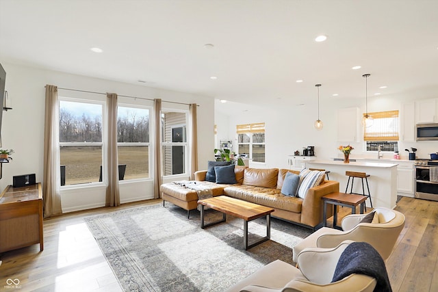 living area with recessed lighting and light wood finished floors