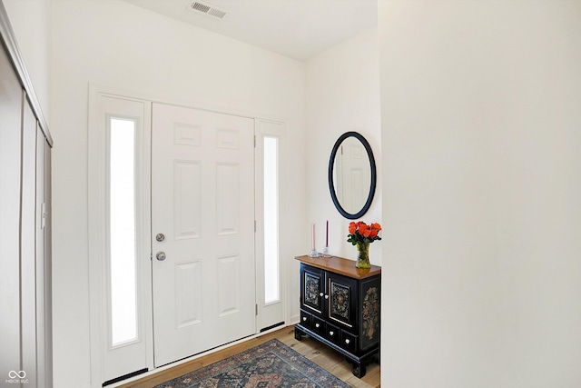 foyer entrance with visible vents and wood finished floors