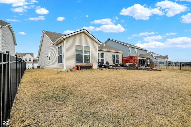 back of house with a yard and a fenced backyard