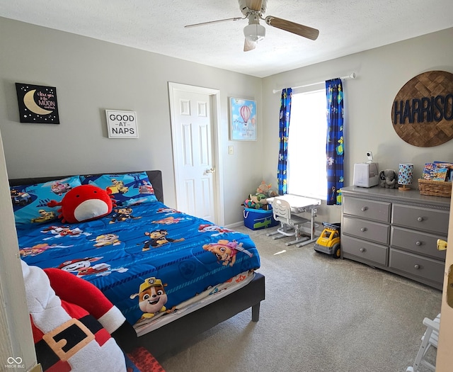 carpeted bedroom featuring ceiling fan and a textured ceiling