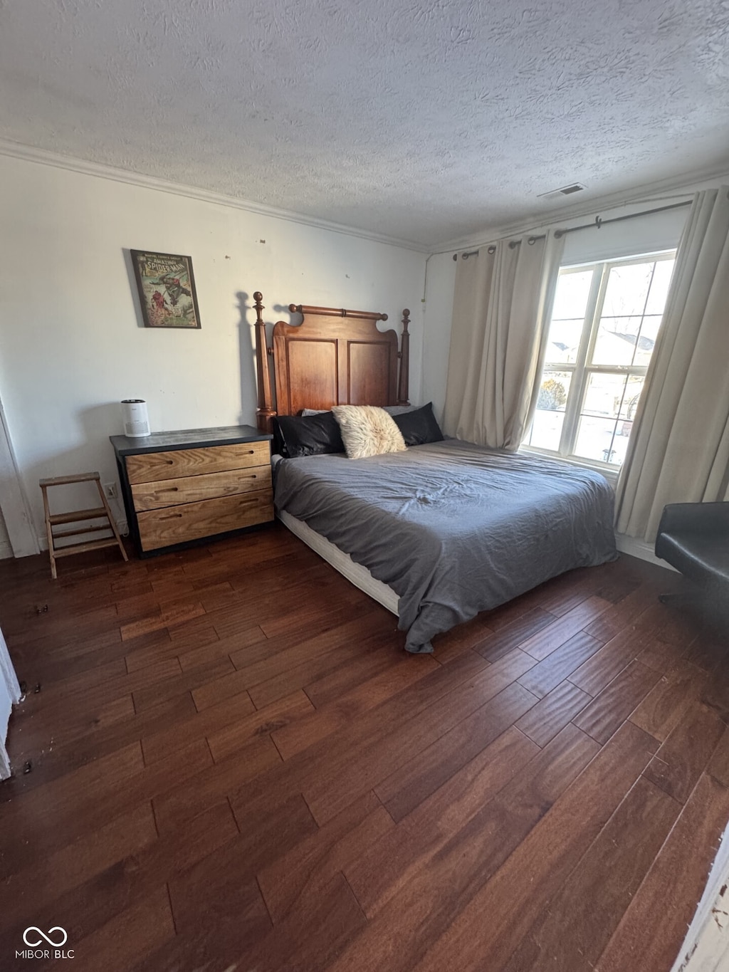 bedroom with crown molding, a textured ceiling, visible vents, and dark wood-type flooring