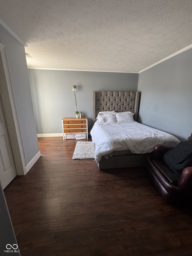 bedroom with dark wood-style floors, a textured ceiling, baseboards, and crown molding